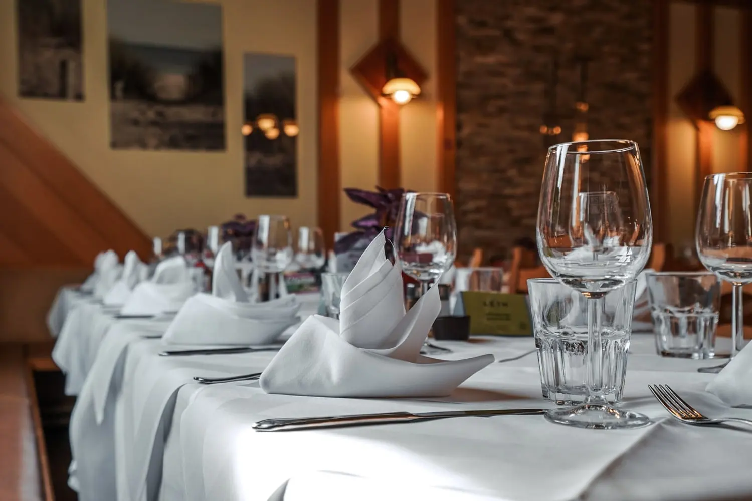 Eine gedeckte Tafel mit weißen Servietten und Gläsern im Restaurant Musil.