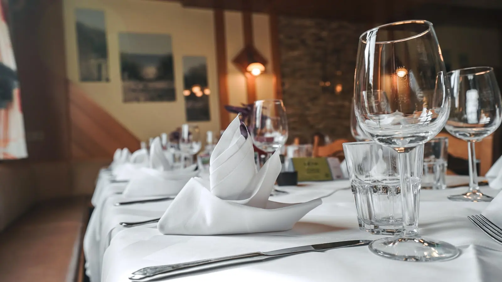 Gedeckte Tische mit Weingläsern und Servietten in der Gaststube des Restaurant Musil.