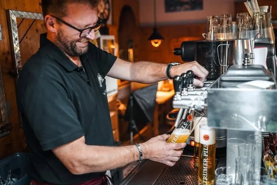 Wolfgang Hierzer schenkt hinter der Schank im Restaurant Musil ein Bier ein.
